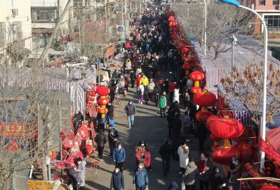 1月8日上午，记者在新区桂林路露天年货市场看到，年货市场内人头攒动，广州道主干道上车流拥堵，年货市场内沿街大红灯笼高高挂起，售卖春联、吊钱等年货的摊位连成一片，喜庆的红色映衬出浓浓的年味，各种兔年白兔形象的玩偶、装饰吊件吸引了孩子们的注意，各式各样年宵花卉色彩缤纷，市民纷纷驻足选购年货，一片热闹非凡的景象。