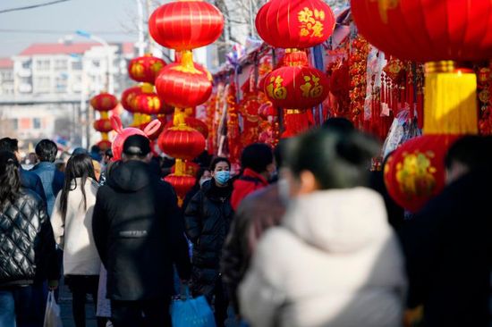 1月8日上午，记者在新区桂林路露天年货市场看到，年货市场内人头攒动，广州道主干道上车流拥堵，年货市场内沿街大红灯笼高高挂起，售卖春联、吊钱等年货的摊位连成一片，喜庆的红色映衬出浓浓的年味，各种兔年白兔形象的玩偶、装饰吊件吸引了孩子们的注意，各式各样年宵花卉色彩缤纷，市民纷纷驻足选购年货，一片热闹非凡的景象。